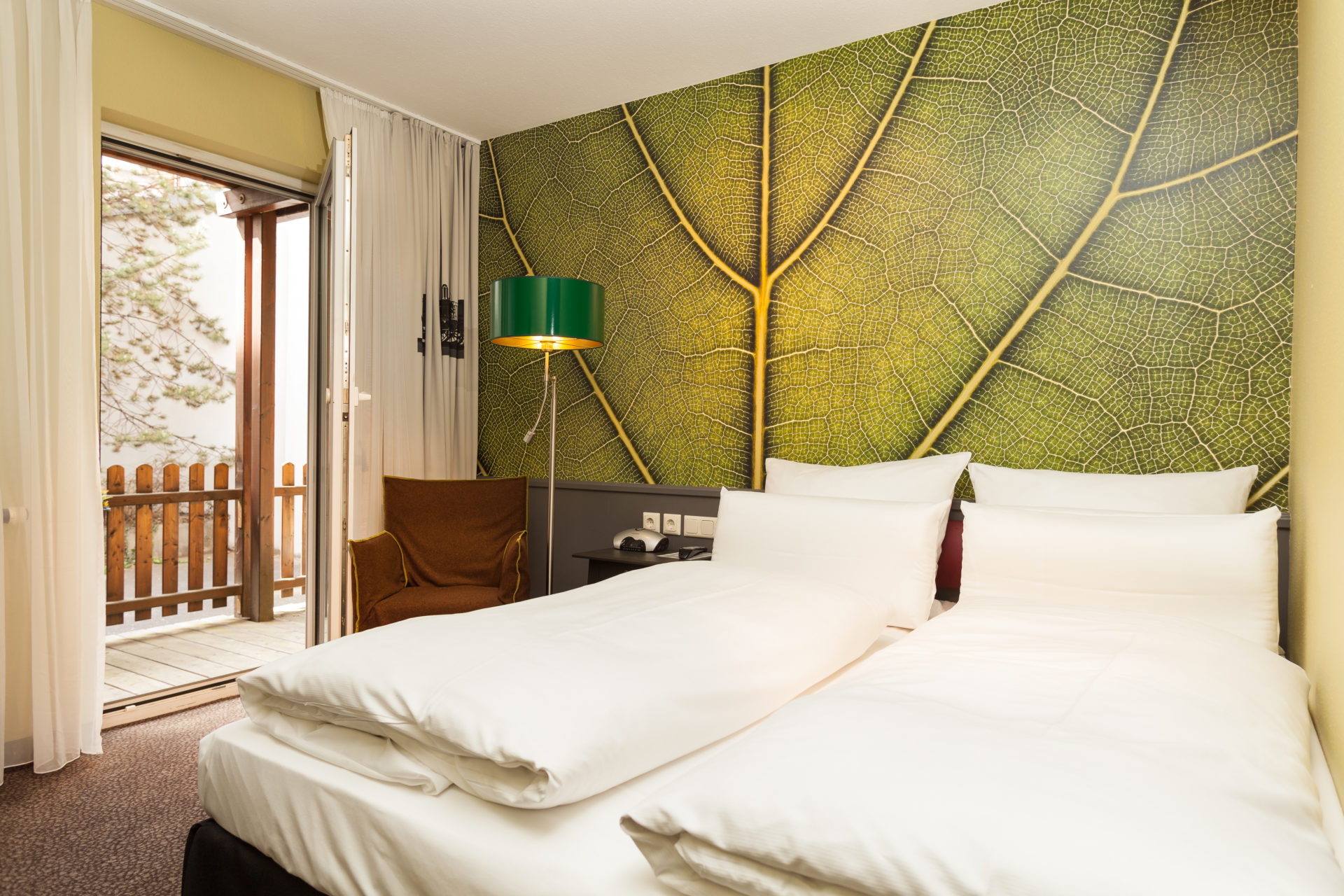 Ein gut belichtetes Hotelzimmer mit Doppelbett und Balkon im Best Western Nürnberg