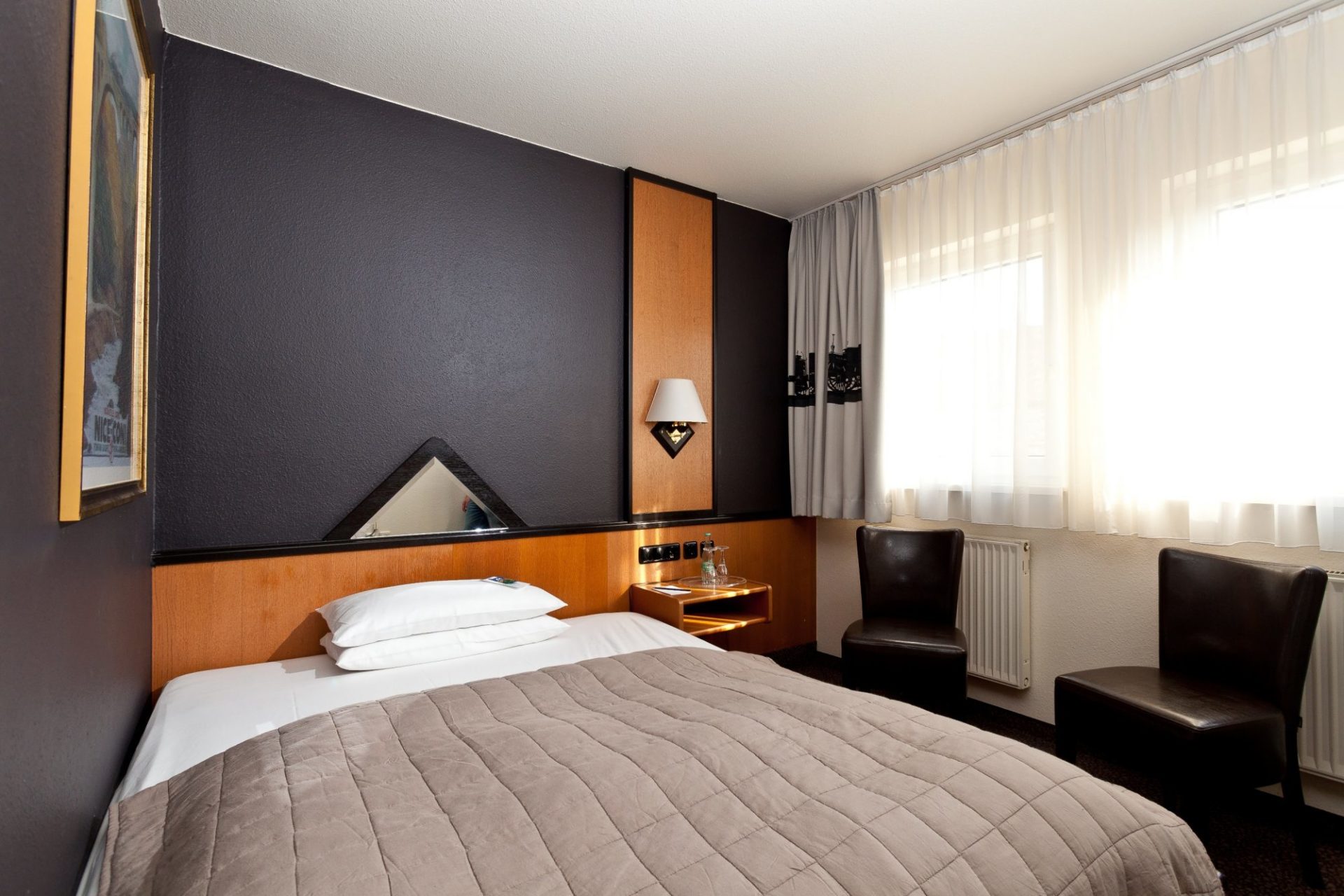 Hotelzimmer mit großem Bett und klassischem Design in Nähe vom Hauptbahnhof